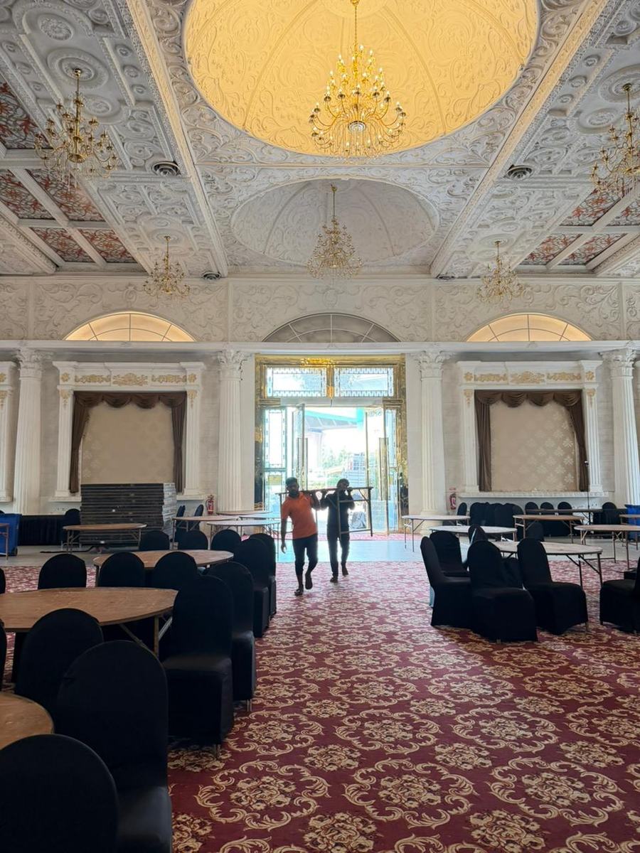 The hall, hours before it becomes a show. Every table, cover and chair placed to a plan someone has to own.